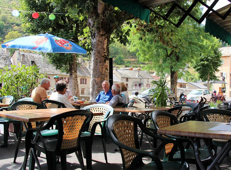 Customers relax over a cold drink at a Café in Le Pont-de-Montvert