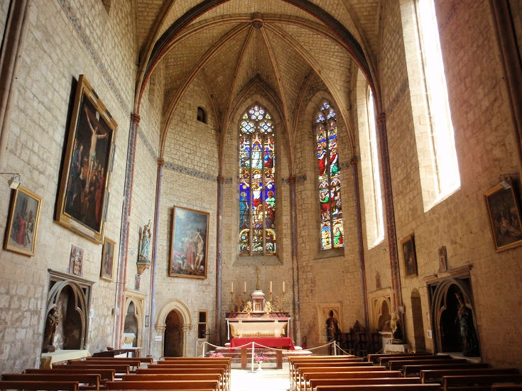 Interior of the church of Saint-Pierre with high vaulted ceiling, tall stained glass windows