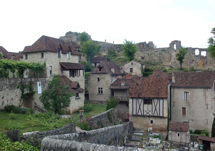 Stone and timbered houses in front of the crumbling stone walls that once enclosed the château belonging to the Cardaillac family