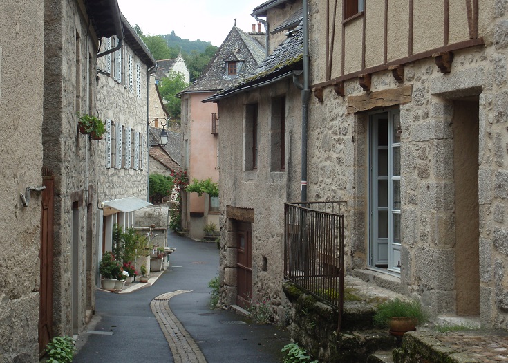 Crooked back street flanked with old stone and timber houses