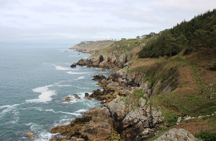 Boat going fishing on the rocky coast of French Brittany on a