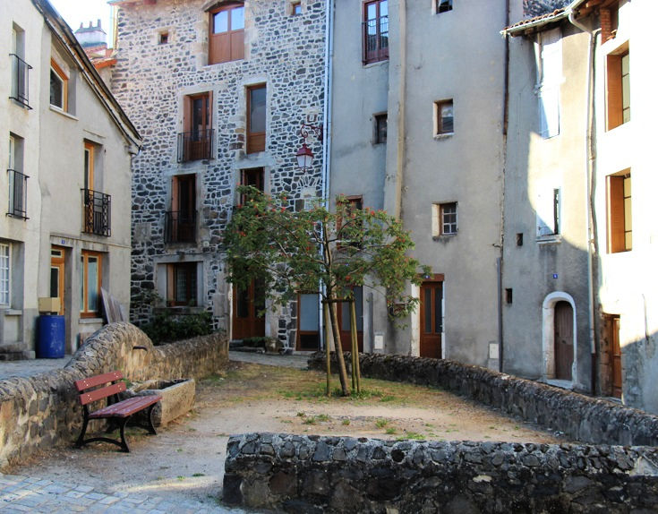 Small square with a low stone wall and a bench seat